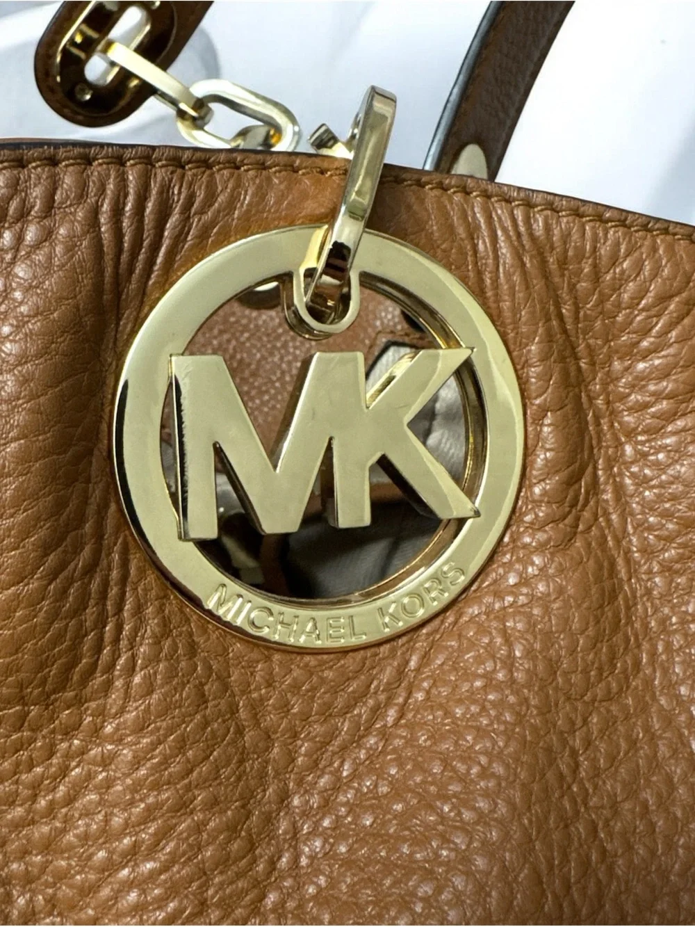 Michael Kors Cognac Pebbled Leather Shoulder Bag with Gold logo on the side.